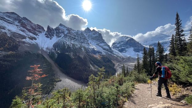 Hiking guide scanning ridgeline and cloud movement in the Canadian Rockies