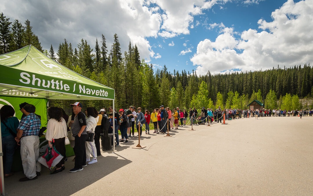 Long line of visitors waiting at the Lake Louise shuttle tent in Banff National Park