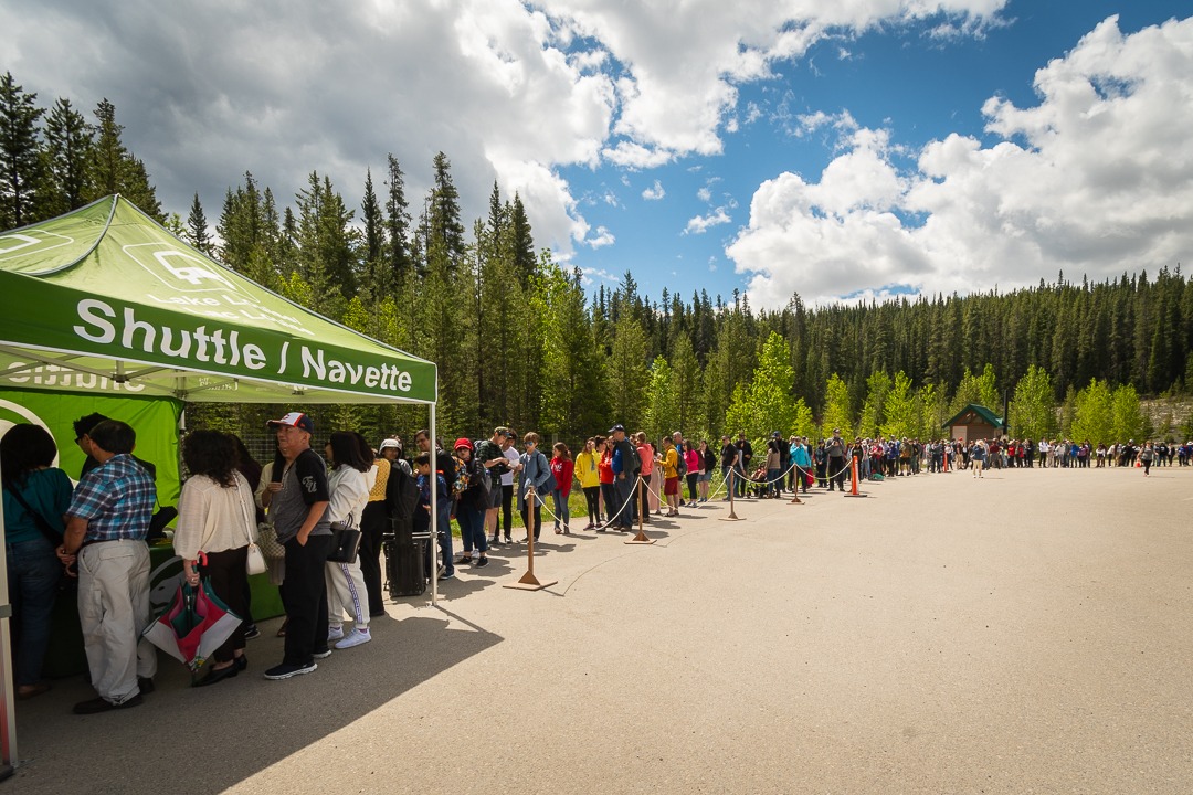 Long line of visitors waiting at the Lake Louise shuttle tent in Banff National Park