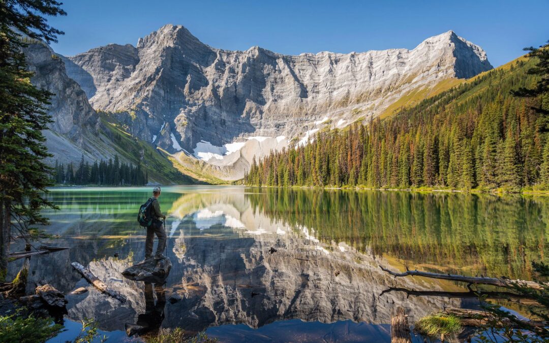 Hiking in Kananaskis stoping at a lake viewing the mountains