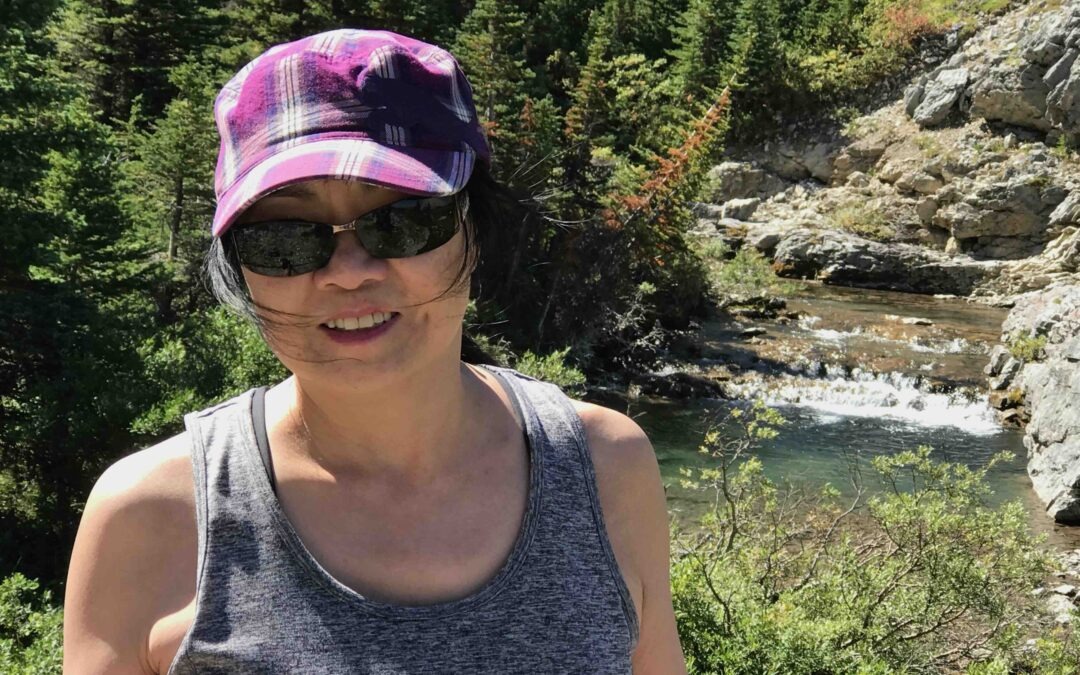 Female guest enjoying a private guided hike in Banff with creek and forest scenery