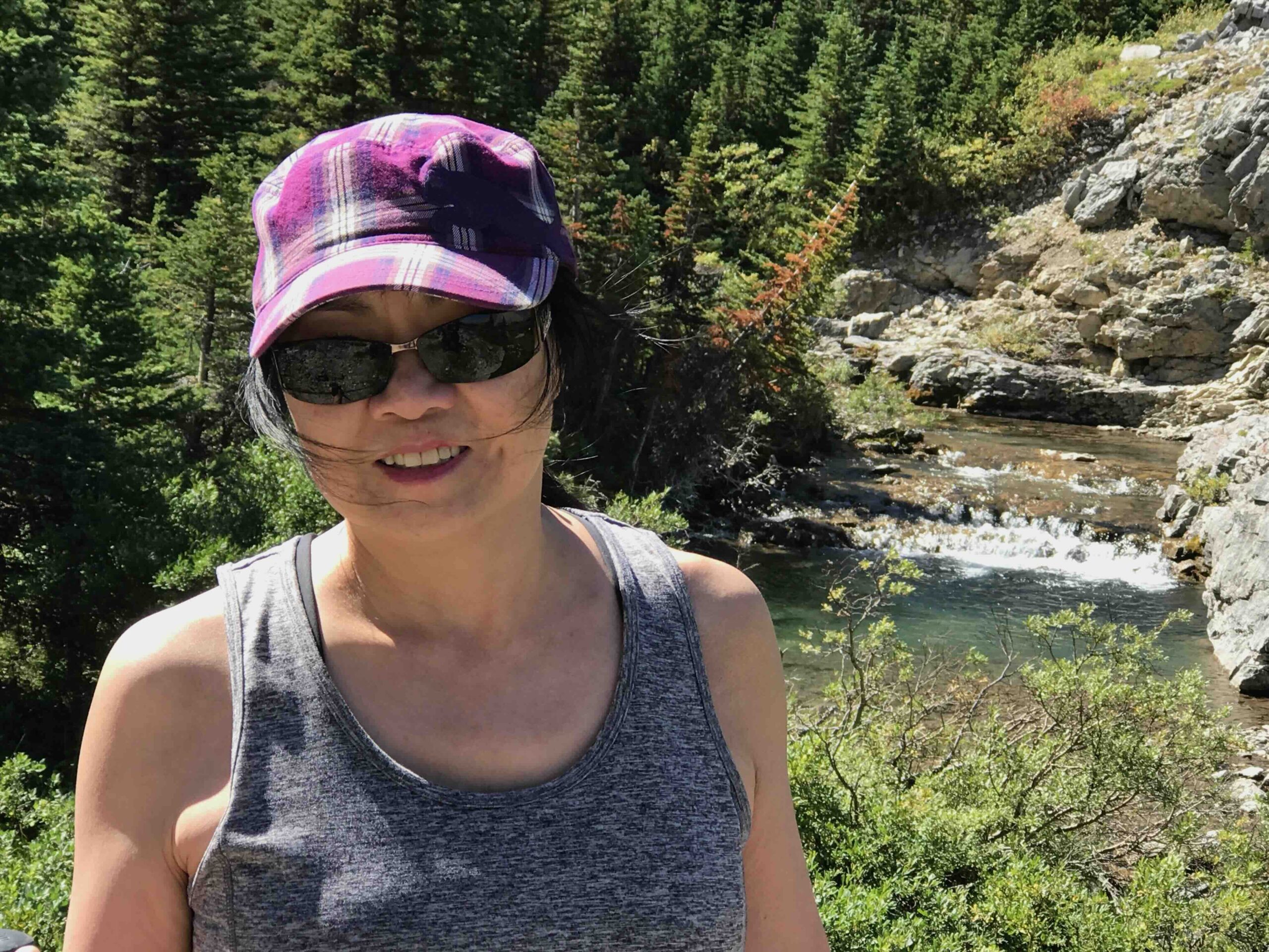 Female guest enjoying a private guided hike in Banff with creek and forest scenery